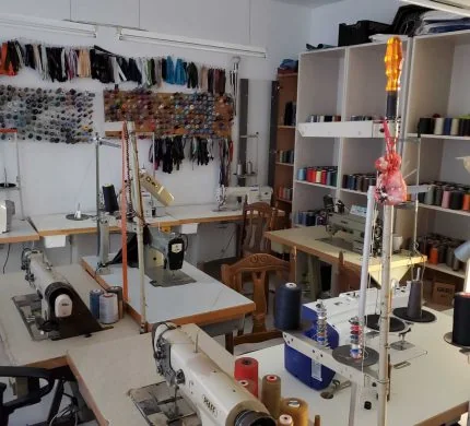 Nähmaschinen, Garnrollen und Material im Atelier